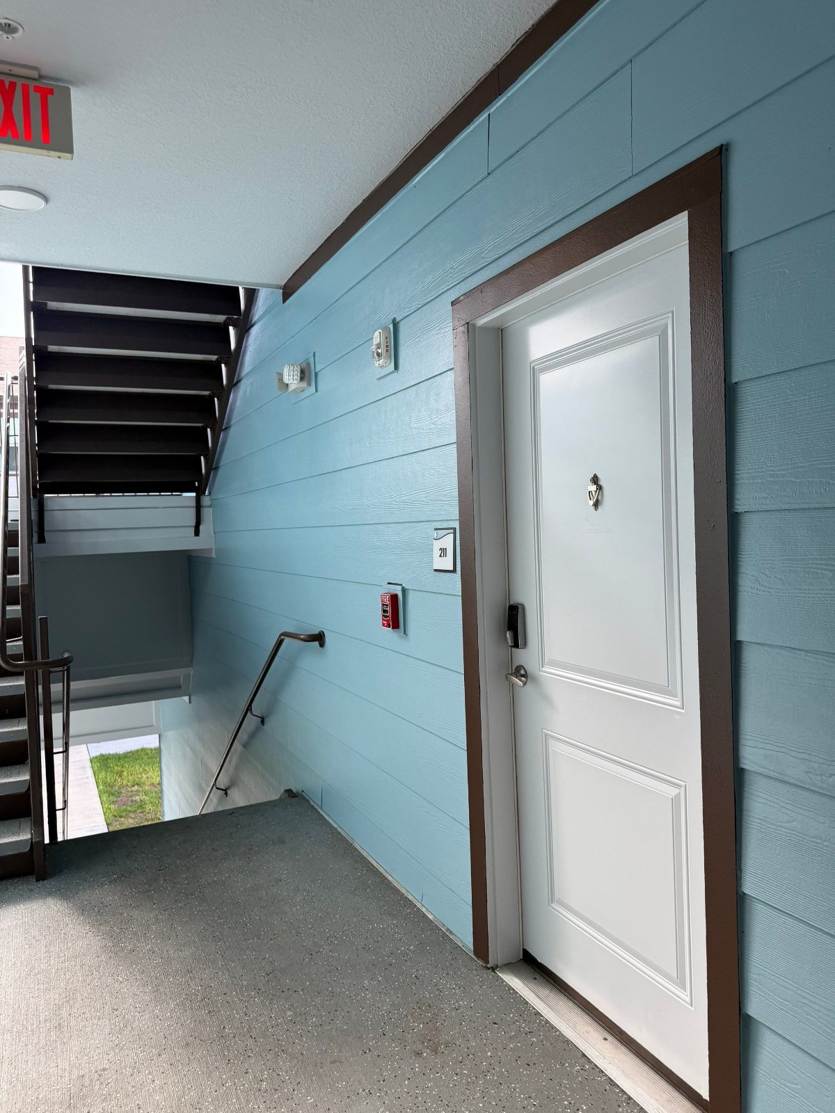 Repainted breezeway siding, trim and unit door at an apartment community in Clearwater, FL