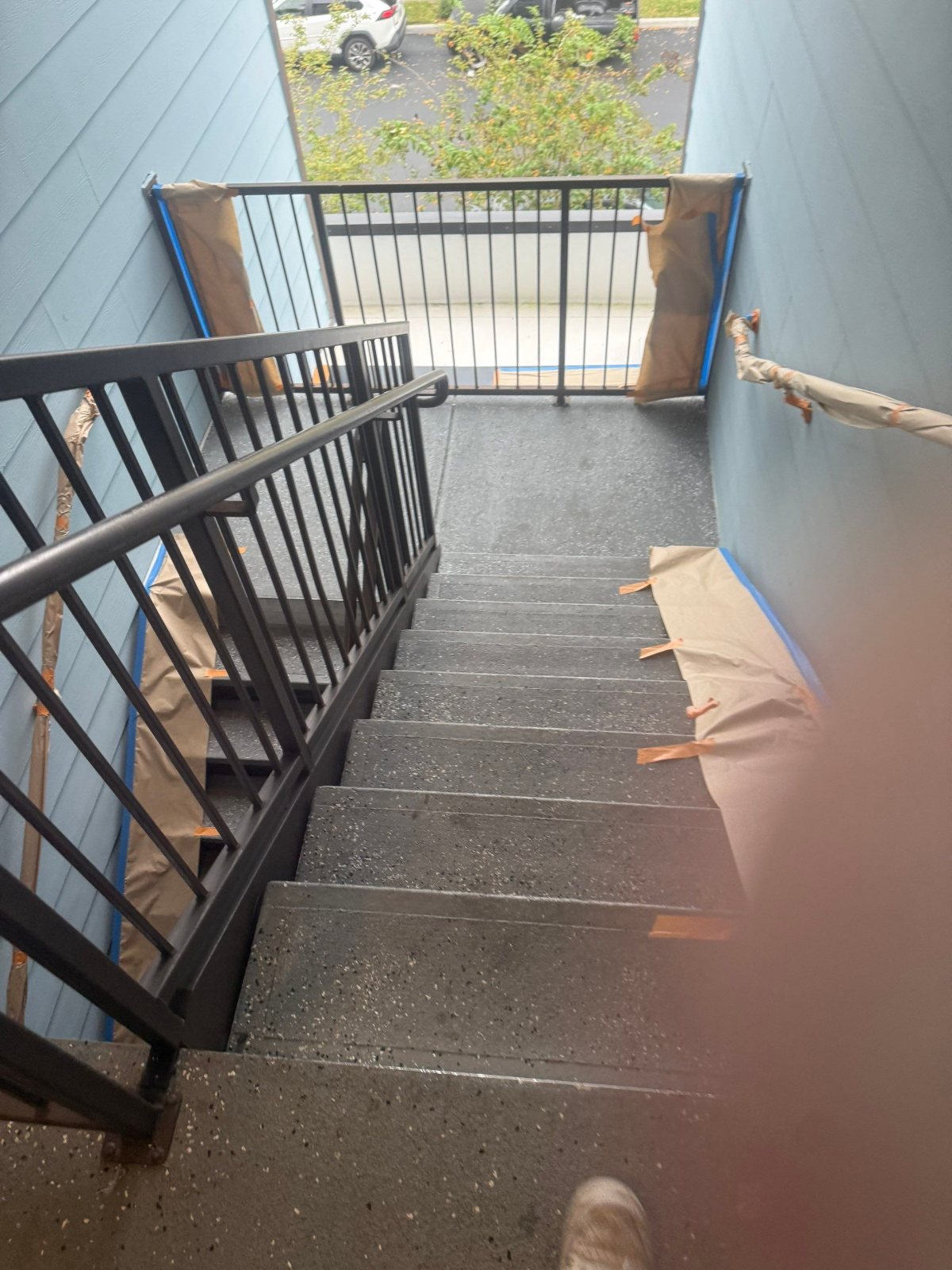 Stair railings and stringers prepped for coating in an apartment breezeway, Clearwater FL
