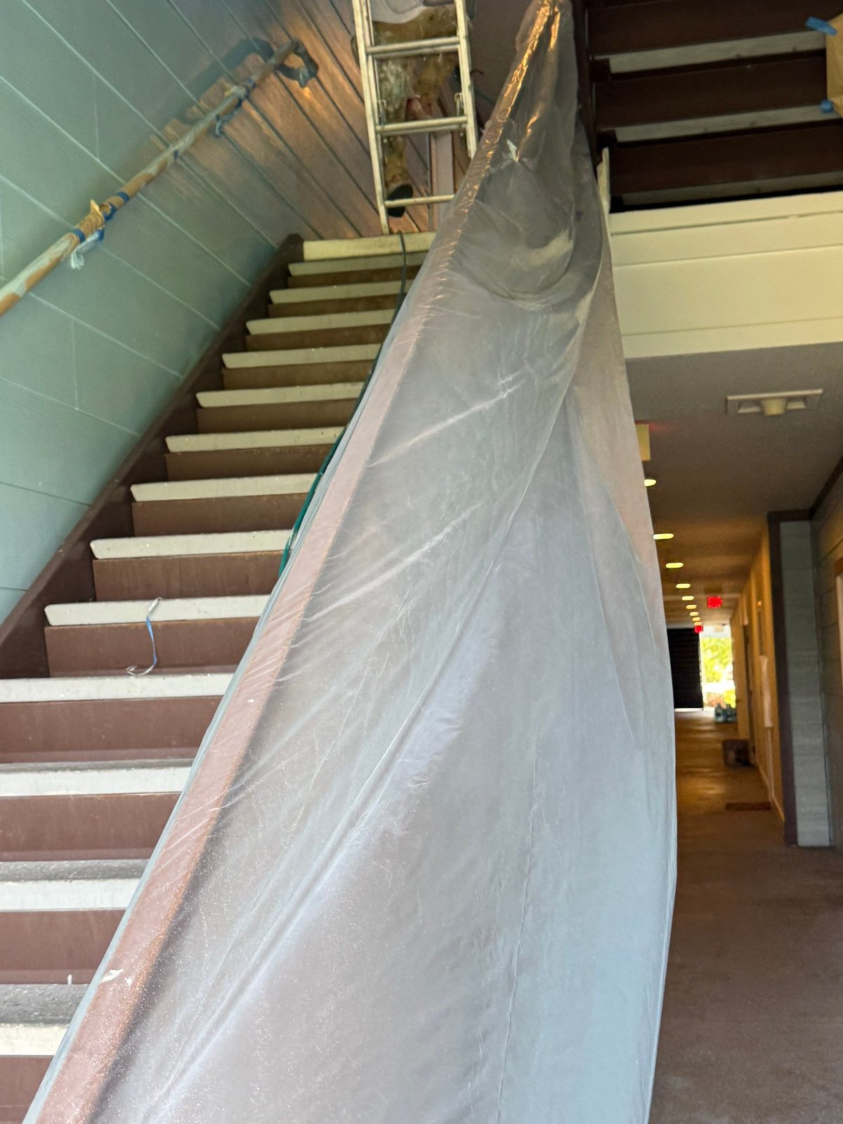 Apartment stairwell masked and protected during breezeway painting