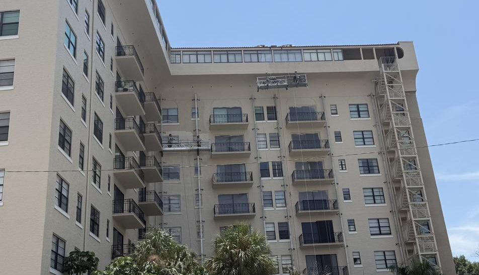 Suspended swing stages painting the upper elevations of Bayshore Royal condominium