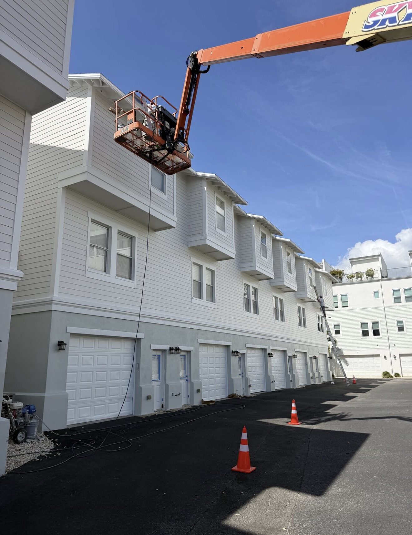 Boom lift repainting townhomes at Belfair Park