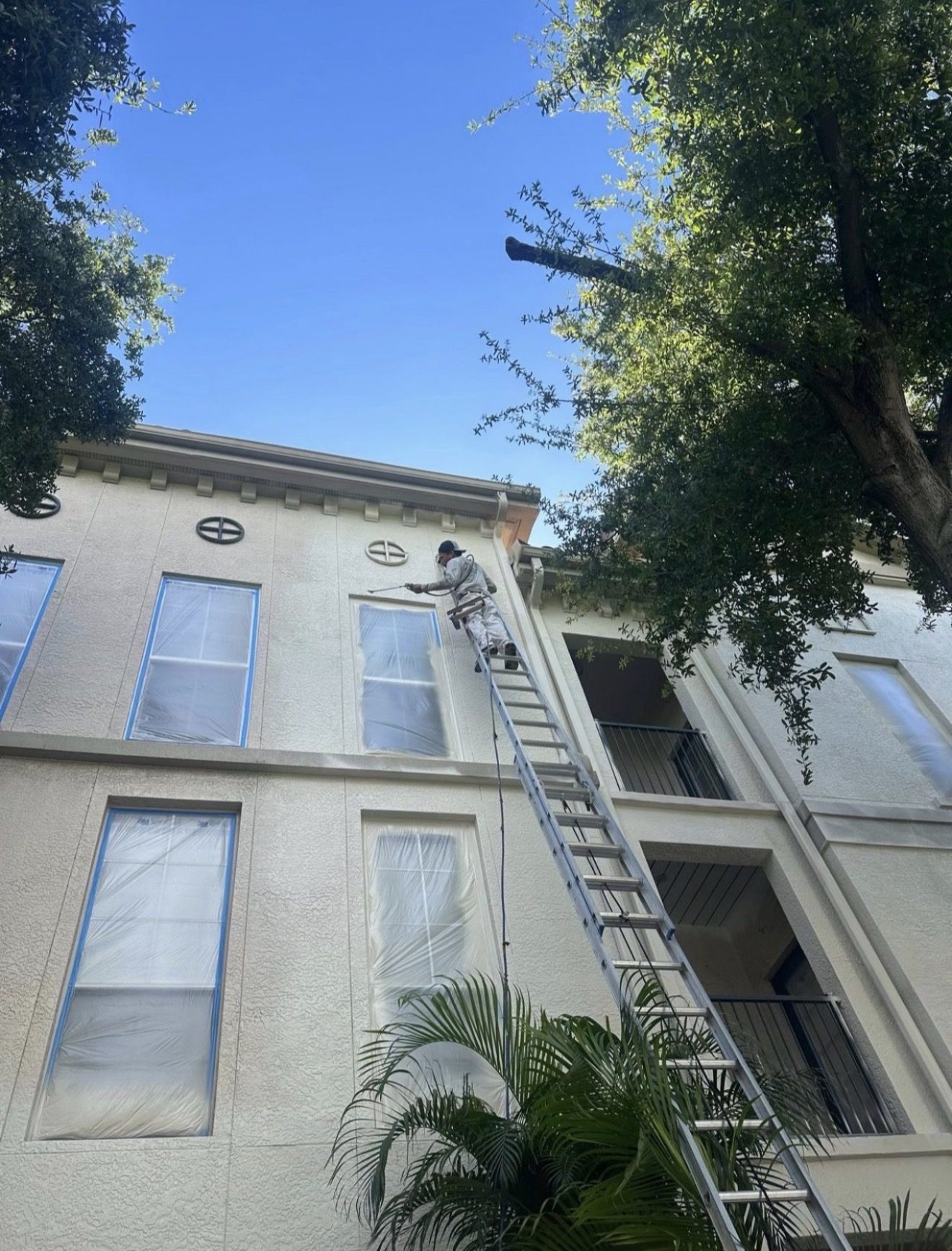 Painter spraying the exterior of Madison SoHo condominium in Tampa FL